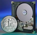 IBM's MicroDrive shown with case opened alongside a United States quarter for size comparison. Courtesy of IBM.