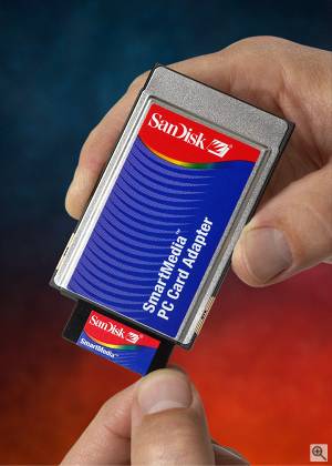 SanDisk's SmartMedia to PC Card adapter, shown in-hand for size comparison. Courtesy of SanDisk. Click for a bigger picture!