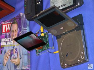 Kodak's Organic EL display to the left of a Panasonic DVD player, both showing the same image.  Note that from near the same angle as each other, the Organic EL display is clearly visible, whilst the LCD display is almost black! Copyright (c) 2000, Michael R. Tomkins, all rights reserved. Click for a bigger picture!