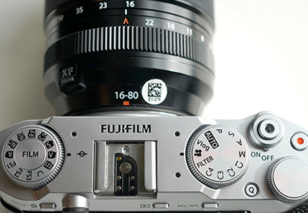 This is a photo of the top of the Fujifilm X-M5 and 16-80mm lens against a white background.